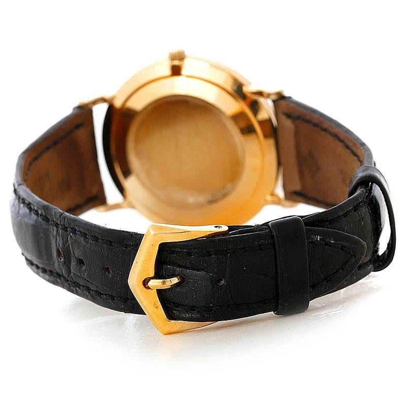 This image shows the rear view of a Patek Philippe Calatrava 3919 Men's Yellow Gold White Dial 3919 Men's Yellow Gold White Dial watch, highlighting its gold case back and leather strap with a gold buckle.