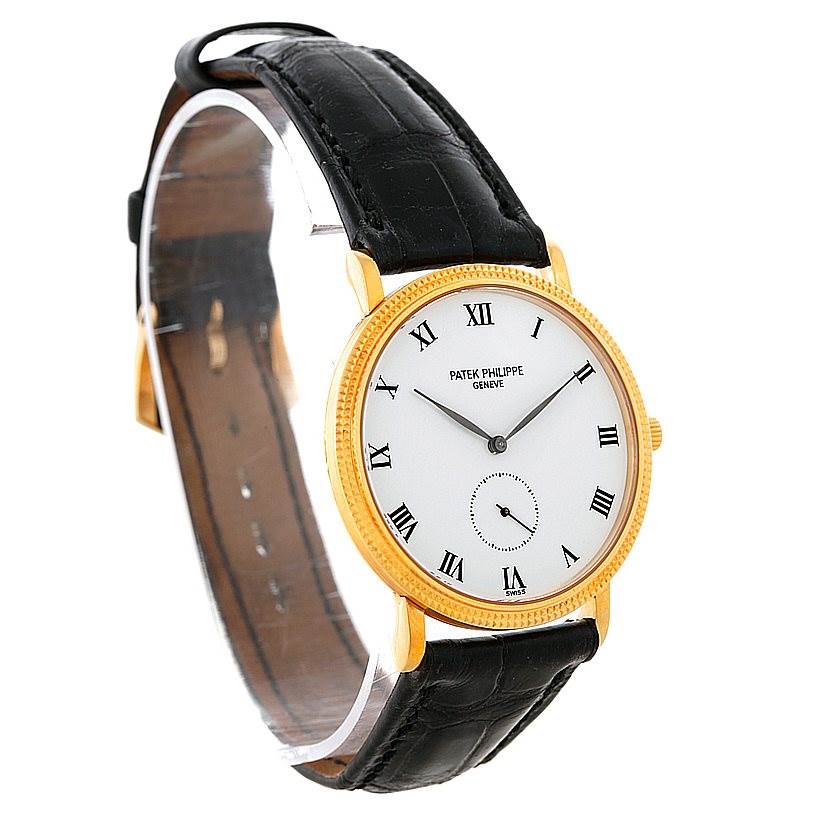 The image shows a side angle of the Patek Philippe Calatrava 3919 Men's Yellow Gold White Dial 3919 Men's Yellow Gold White Dial watch, highlighting its gold casing, black leather strap, and Roman numeral dial.