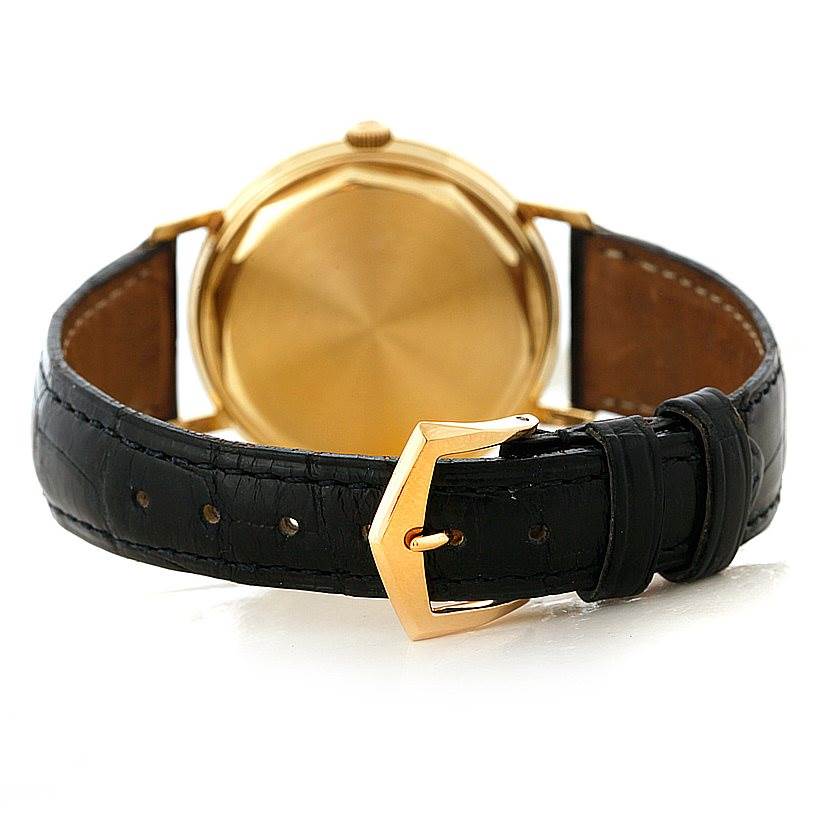 The image shows the back view of the Vintage Patek Philippe watch displaying its gold case and black leather strap with a gold buckle.