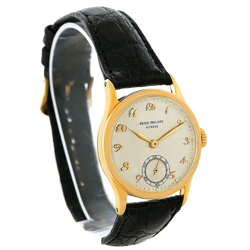 The image shows a front angle view of a Vintage Patek Philippe watch, highlighting its gold case, dial, and black strap.