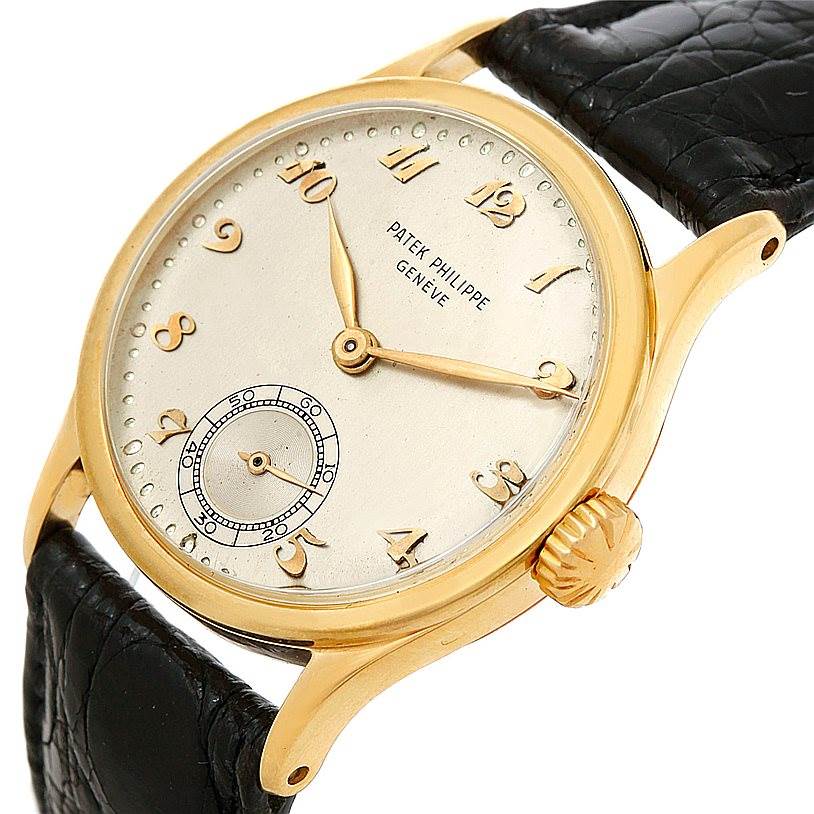 The image shows a Vintage Patek Philippe watch at a slight angle, highlighting its gold case, dial, black leather strap, and crown.