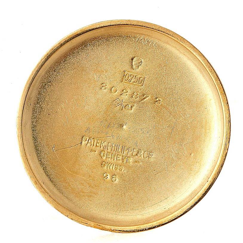 The image shows the inside case back of a vintage Patek Philippe watch, featuring the brand
s engraving and serial numbers.