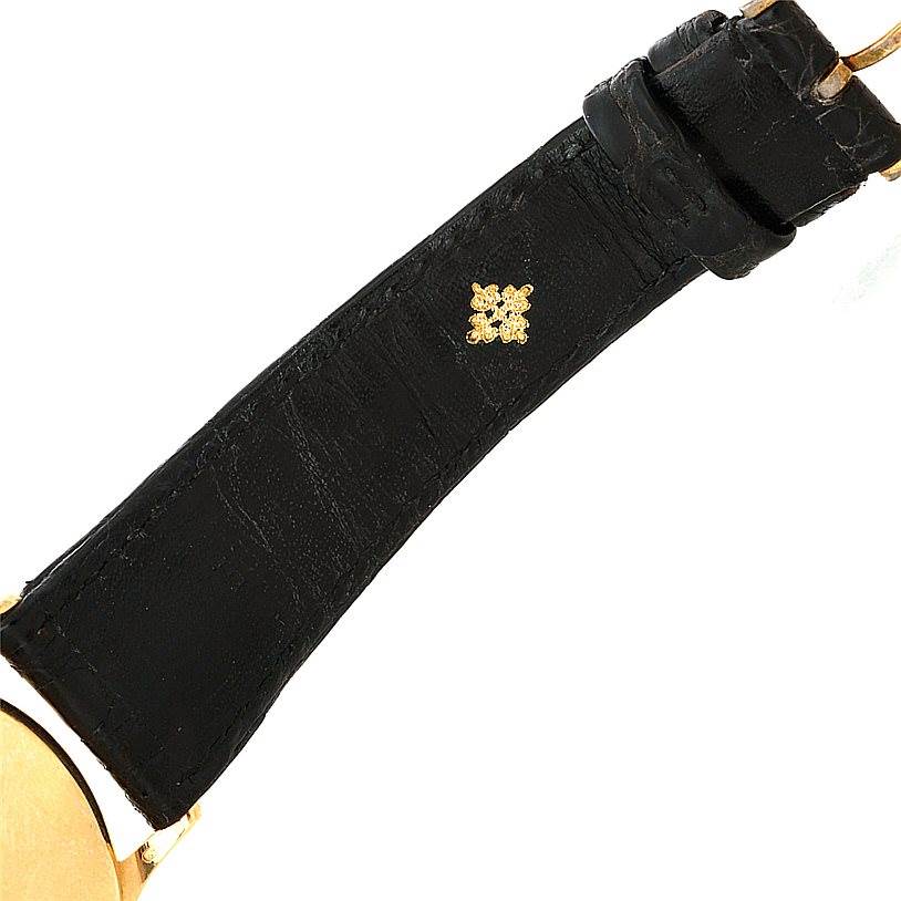The image shows the black leather strap and a partial view of the gold case of a Vintage Patek Philippe watch.