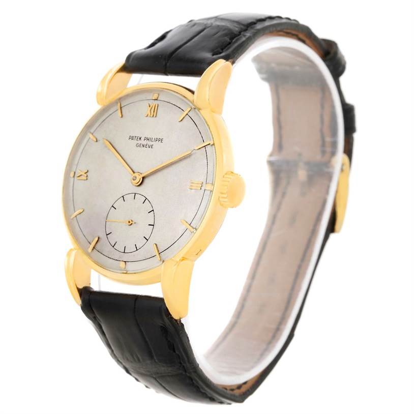 The image shows a side-front angle of a Patek Philippe Vintage watch, highlighting its dial, gold casing, and black leather strap.