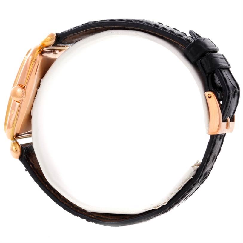 This side view of the Patek Philippe Calatrava 2493 Men's Rose Gold Silver Dial 2493 Men's Rose Gold Silver Dial watch showcases the case, crown, and leather strap with a clasp.