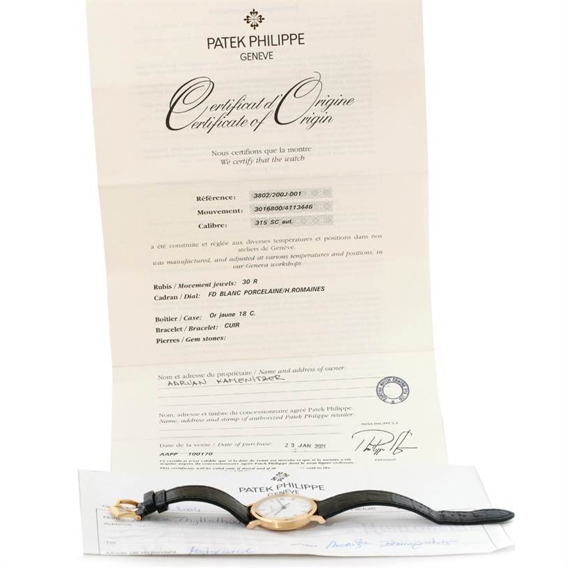 The image shows a Patek Philippe Calatrava 3802 Men's Yellow Gold White Dial 3802 Men's Yellow Gold White Dial watch placed below its Certificate of Origin, viewed from the top.