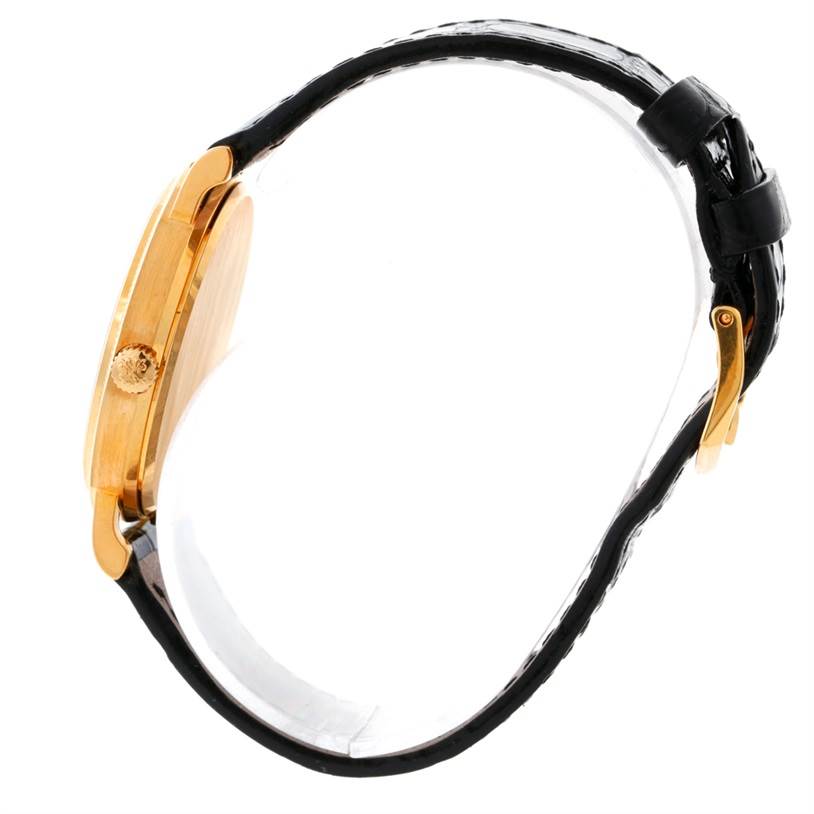 The Patek Philippe Calatrava 3802 Men's Yellow Gold White Dial 3802 Men's Yellow Gold White Dial watch is shown from a side angle, displaying its gold case, crown, and black leather strap.