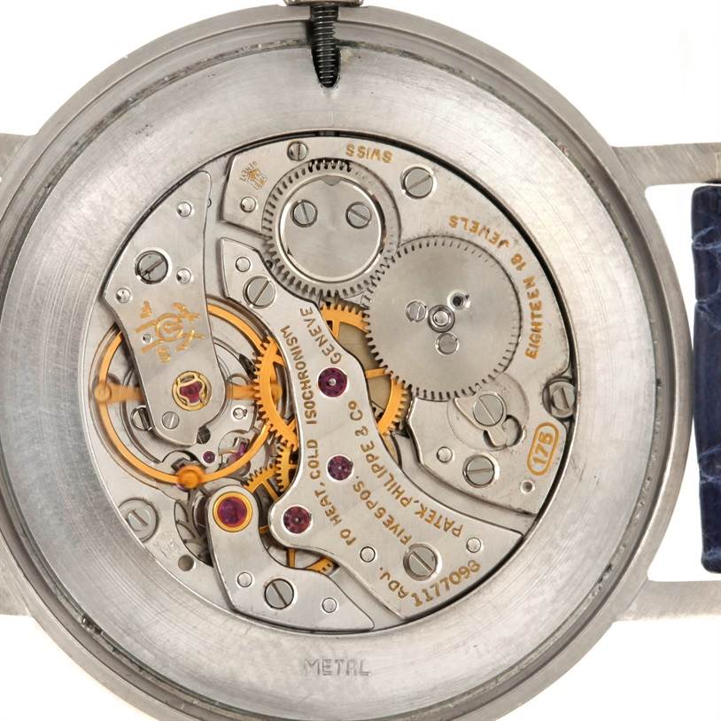 The image shows the intricate inner mechanics of the Patek Philippe Vintage watch, focusing on its gears and movement components.