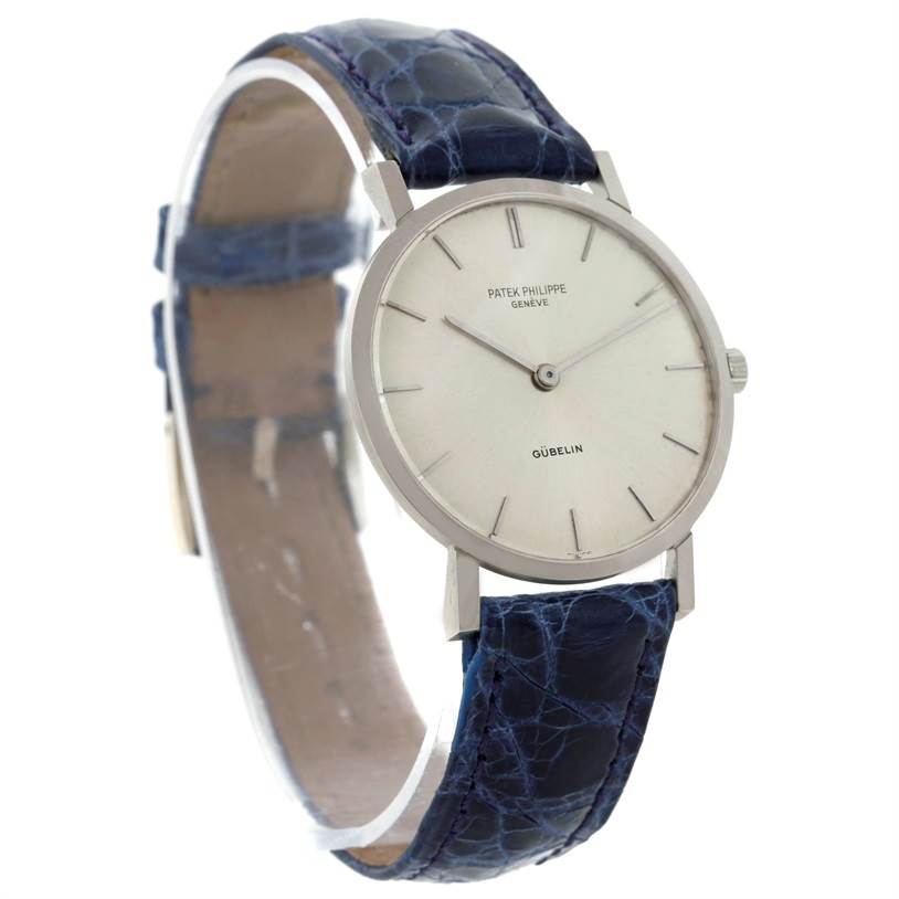 The image shows a frontal angle of a Vintage Patek Philippe watch with a blue crocodile leather strap and a minimalist dial.