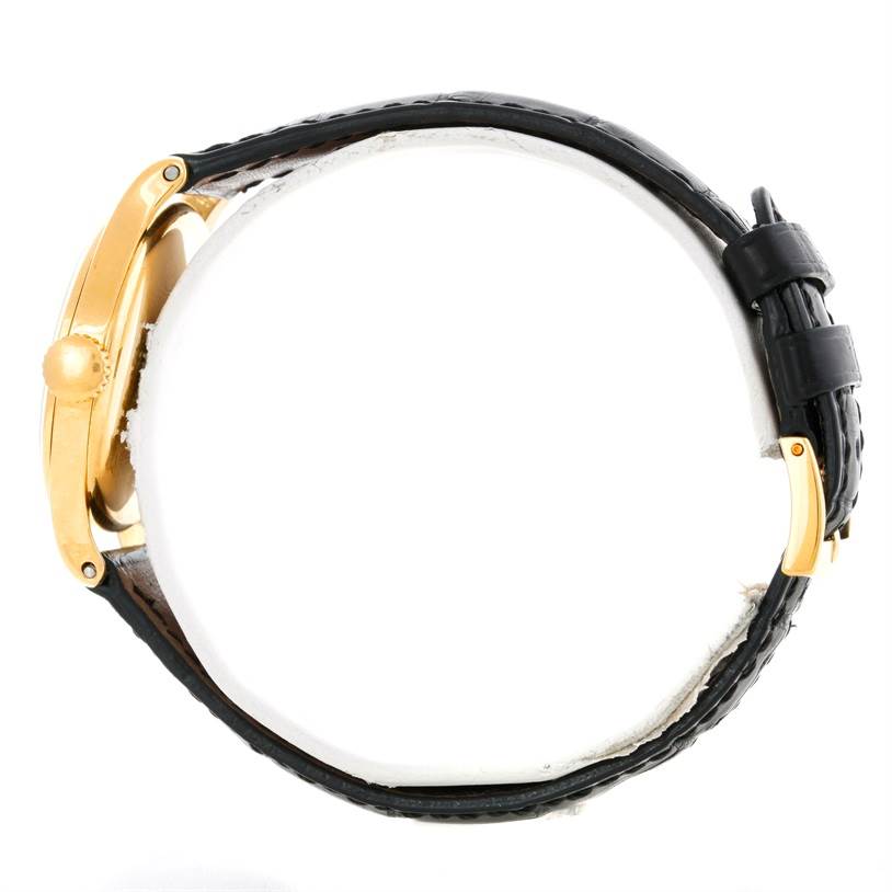 The image shows a side view of a Vintage Patek Philippe watch, highlighting its gold casing, crown, and black leather strap.