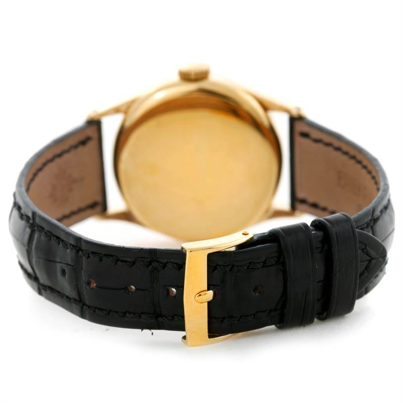 The image shows the rear view of the Patek Philippe Vintage model watch, highlighting the gold case back and black leather strap with buckle.