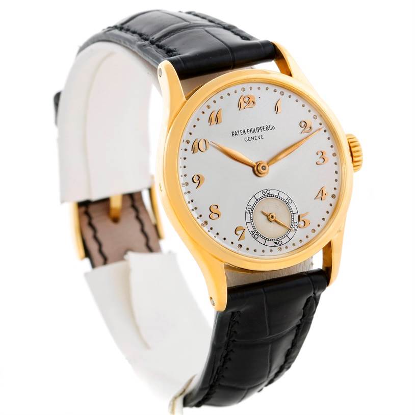 The Patek Philippe Vintage model watch is shown from an angled front view, highlighting the face, gold casing, and black leather strap.