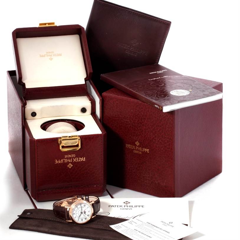 The image shows the Patek Philippe 5059R Men
s Rose Gold White Dial 5059R Men
s Rose Gold White Dial Perpetual Calendar Retrograde 18k Rose Gold 5059R watch with its box, manual, and warranty documents.