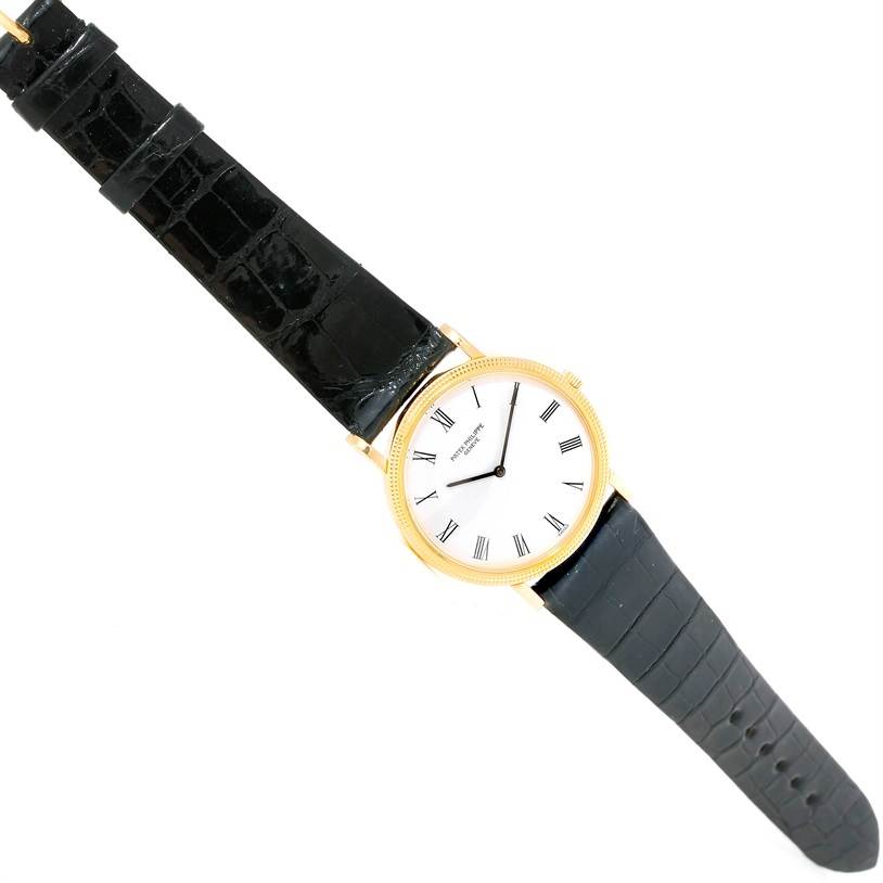 The image shows a Patek Philippe Calatrava 3520 Men's Yellow Gold White Dial 3520 Men's Yellow Gold White Dial watch at a top-down angle, displaying its dial, case, and black leather strap.