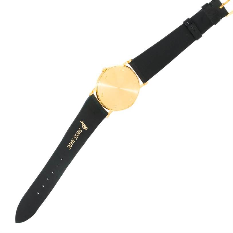 The image shows the front of a Patek Philippe Calatrava 3520 Men's Yellow Gold White Dial 3520 Men's Yellow Gold White Dial watch, highlighting its gold case and black strap.