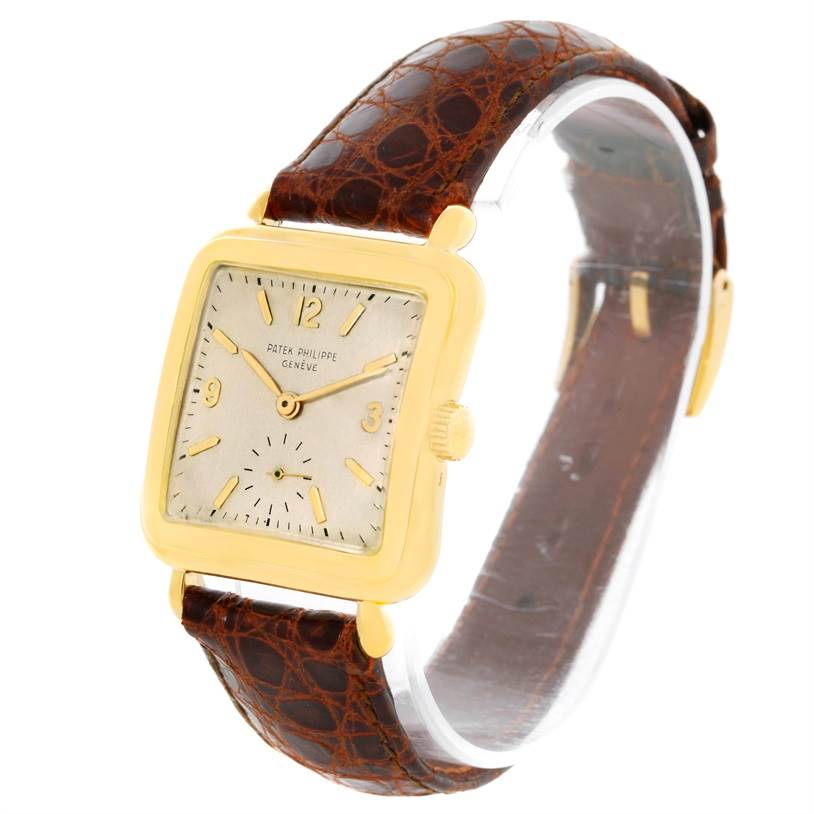 The Vintage Patek Philippe watch is shown at an angle highlighting the square face, gold casing, and brown leather strap.