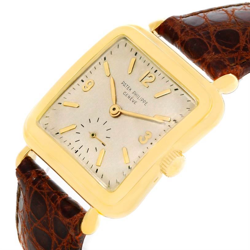 This image shows a Vintage Patek Philippe watch from an angled view, displaying its square dial, gold case, crown, and brown leather strap.