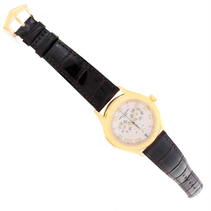 The image shows a top-down view of the Patek Philippe Complications 5035R Men
s Yellow Gold Silver Dial 5035R Men
s Yellow Gold Silver Dial watch, highlighting its dial, crown, and leather strap.