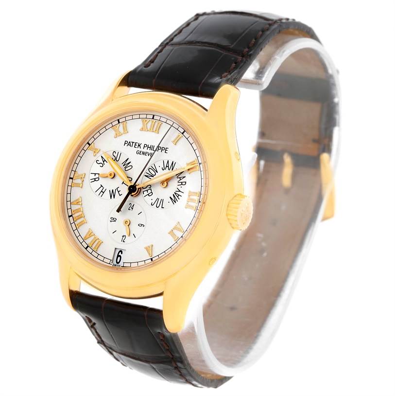 The image shows a Patek Philippe Complications 5035R Men
s Yellow Gold Silver Dial 5035R Men
s Yellow Gold Silver Dial watch with a gold case and black leather strap, viewed from an angled perspective.