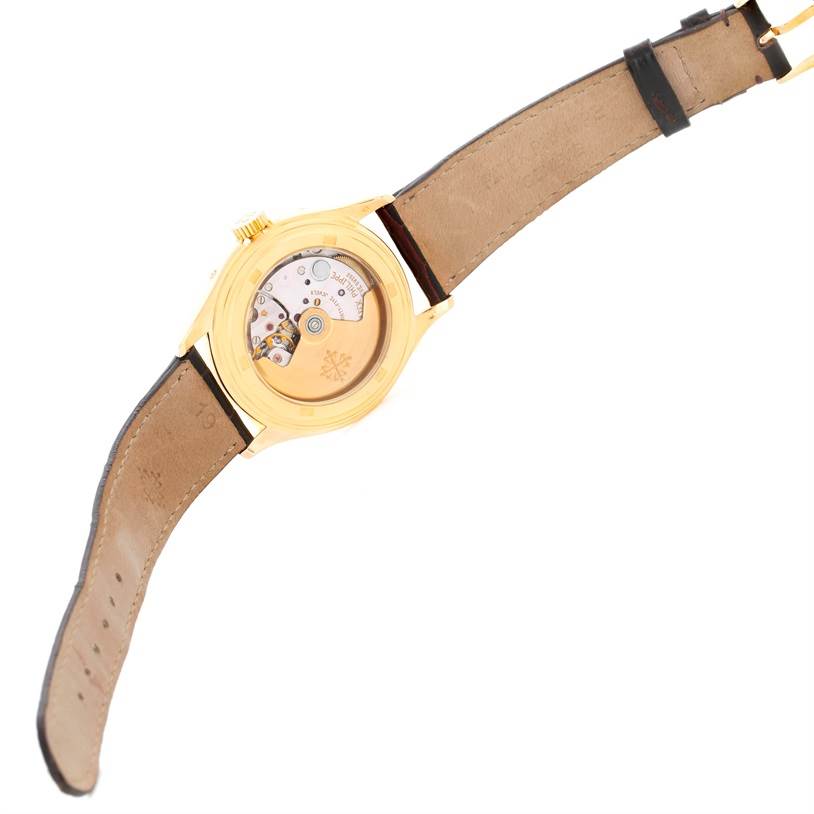 The image shows the back view of a Patek Philippe Complications 5035R Men
s Yellow Gold Silver Dial 5035R Men
s Yellow Gold Silver Dial model watch, highlighting its case back and internal movement.