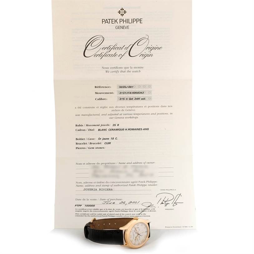 The image shows a Patek Philippe Complications 5035R Men
s Yellow Gold Silver Dial 5035R Men
s Yellow Gold Silver Dial model watch at an angle, with its certificate of origin in the background.