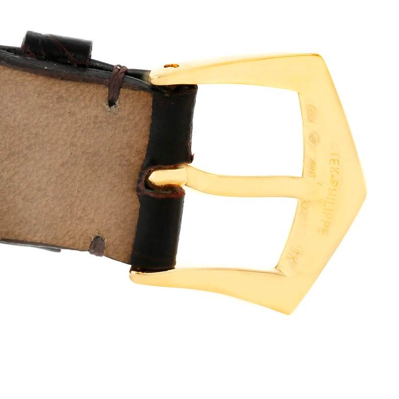 The image shows the gold buckle and leather strap of a Patek Philippe Complications 5035R Men
s Yellow Gold Silver Dial 5035R Men
s Yellow Gold Silver Dial watch from a close-up angle.