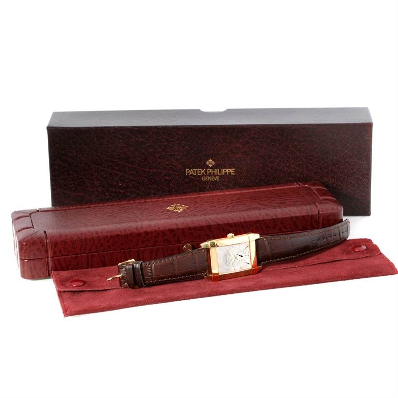 The image shows a Patek Philippe Gondolo 5111J Men's Yellow Gold Silver Dial 5111J Men's Yellow Gold Silver Dial watch laid flat with its brown leather strap, placed in front of its branded case and box.