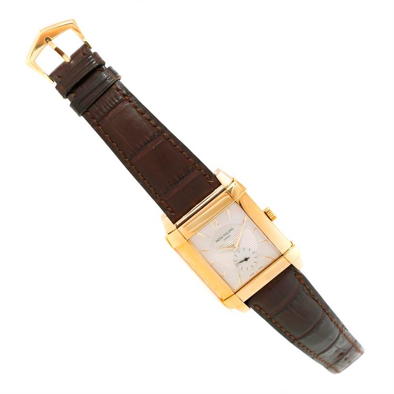The image shows a Patek Philippe Gondolo 5111J Men's Yellow Gold Silver Dial 5111J Men's Yellow Gold Silver Dial watch from a slight angle, highlighting the rectangular face, brown leather strap, and gold casing.