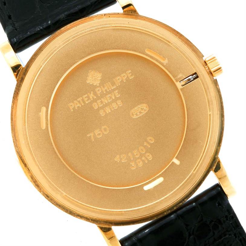 The image shows the back case of a Patek Philippe Calatrava 3919 Men's Yellow Gold White Dial 3919 Men's Yellow Gold White Dial watch, focusing on its inscriptions and the black leather strap.