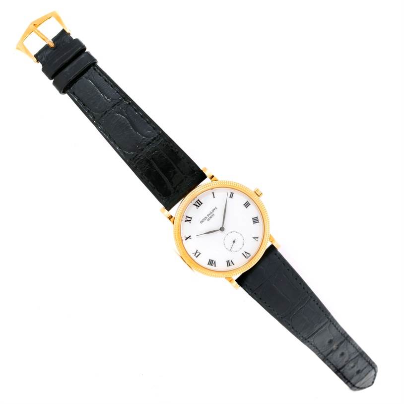 The image shows a top view of a Patek Philippe Calatrava 3919 Men's Yellow Gold White Dial 3919 Men's Yellow Gold White Dial watch, displaying its dial, bezel, and black leather strap.