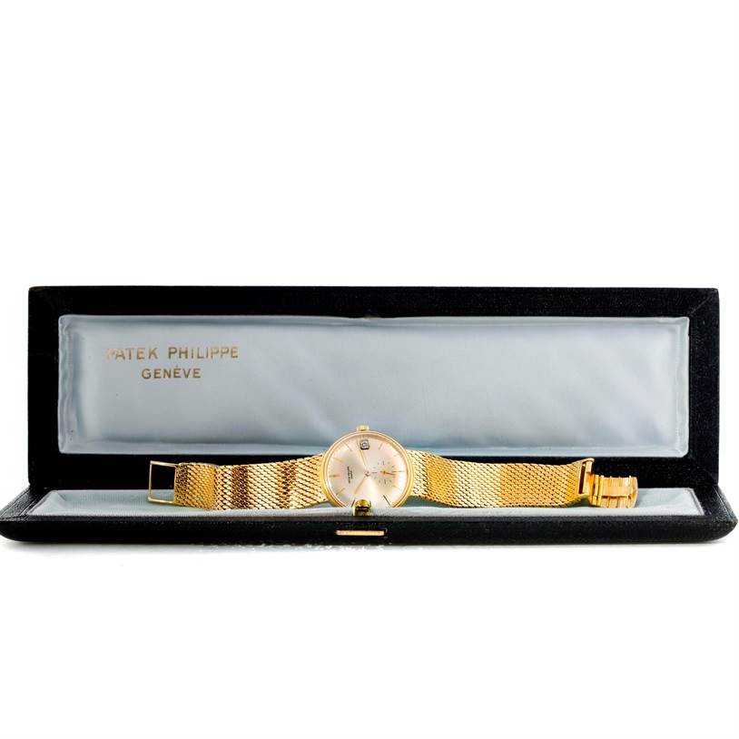 The image shows a Vintage Patek Philippe watch laid flat in its open box, displaying the face and gold mesh band.