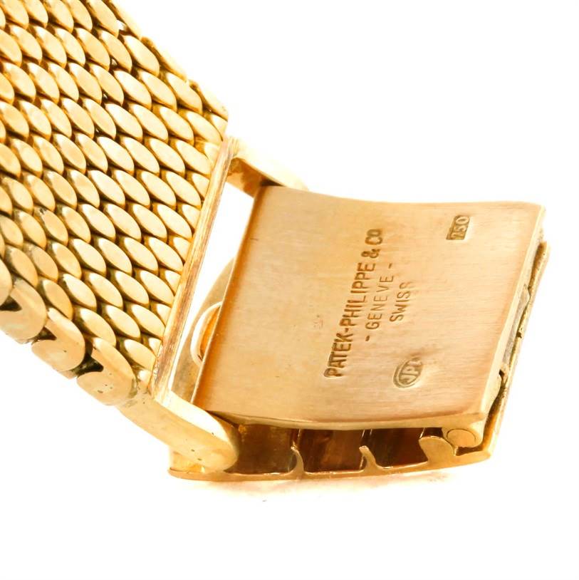 This image shows a close-up of the clasp mechanism of a Vintage Patek Philippe watch, highlighting the signature and metal band.