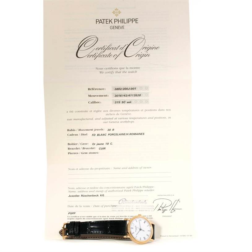 The image shows a Patek Philippe Calatrava 3802 Men's Yellow Gold White Dial 3802 Men's Yellow Gold White Dial watch placed in front of its Certificate of Origin.