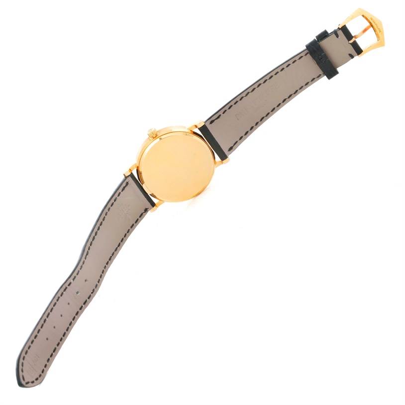 The image shows the back view of a Patek Philippe Calatrava 3802 Men's Yellow Gold White Dial 3802 Men's Yellow Gold White Dial watch, with a gold case and a beige leather strap.