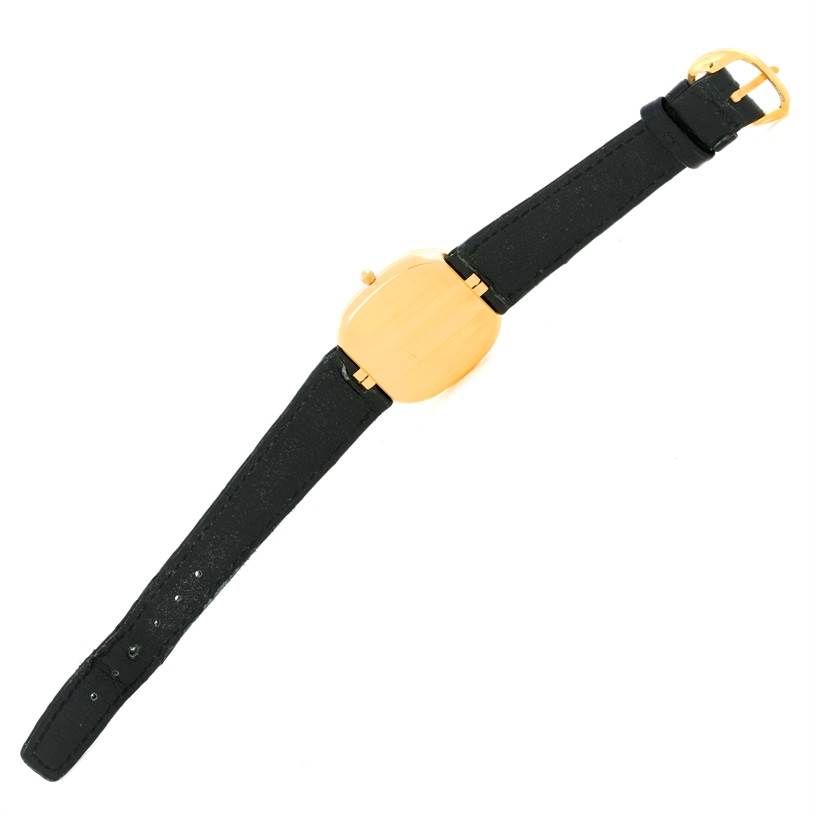 The image shows a top view of a Patek Philippe Golden Ellipse 3738 Men's Yellow Gold Blue Dial 3738 Men's Yellow Gold Blue Dial watch with a black strap and a gold buckle.