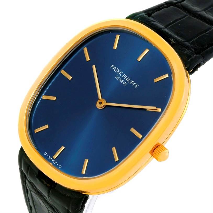 The Patek Philippe Golden Ellipse 3738 Men's Yellow Gold Blue Dial 3738 Men's Yellow Gold Blue Dial watch is shown at an angled view, displaying the blue face, gold case, and black leather strap.