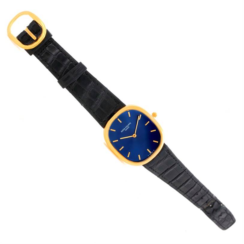 The image shows a Patek Philippe Golden Ellipse 3738 Men's Yellow Gold Blue Dial 3738 Men's Yellow Gold Blue Dial watch from a top-down view, highlighting the face, strap, and buckle.