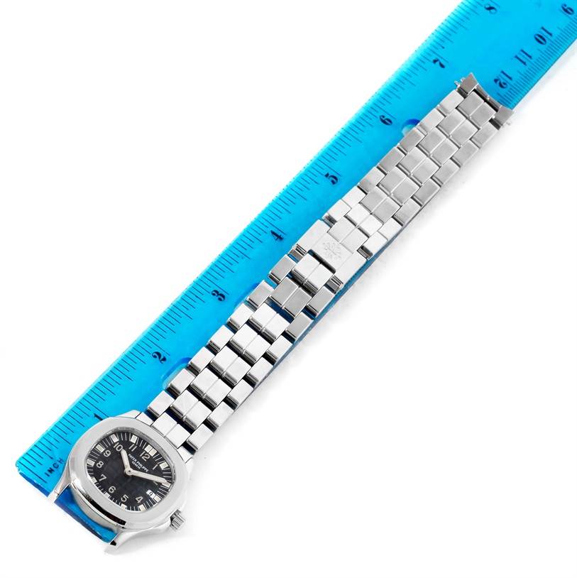 The image displays a Patek Philippe Aquanaut 4960/1A-001 Women's Stainless Steel Black Dial 4960/1A-001 Women's Stainless Steel Black Dial watch with its bracelet laid flat, measured against a ruler.