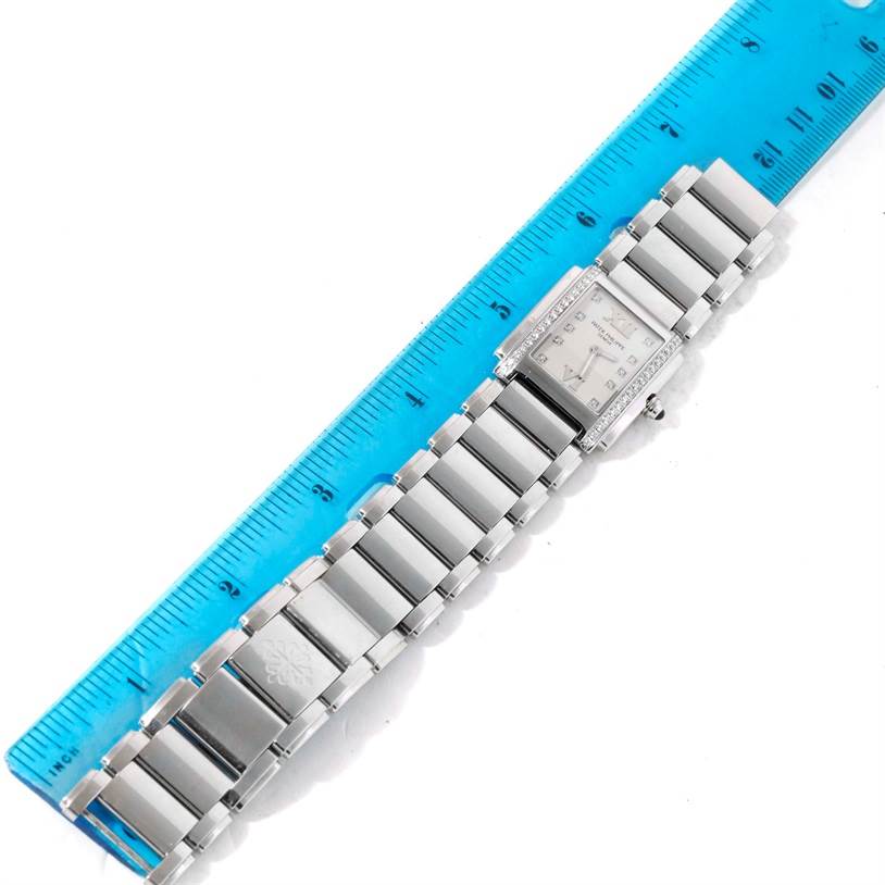 The Patek Philippe Twenty-4 4910/10A-011 Women's Stainless Steel Silver Dial 4910/10A-011 Women's Stainless Steel Silver Dial watch is shown from a top-down angle, displaying the full bracelet and dial next to a blue ruler.