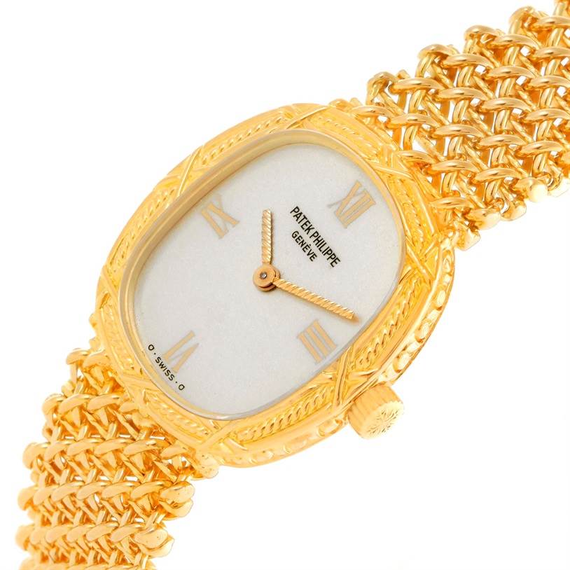 The image shows a Patek Philippe Vintage 4523/1 Women's Yellow Gold Silver Dial 4523/1 Women's Yellow Gold Silver Dial watch angled to display its face, woven bracelet, and crown.