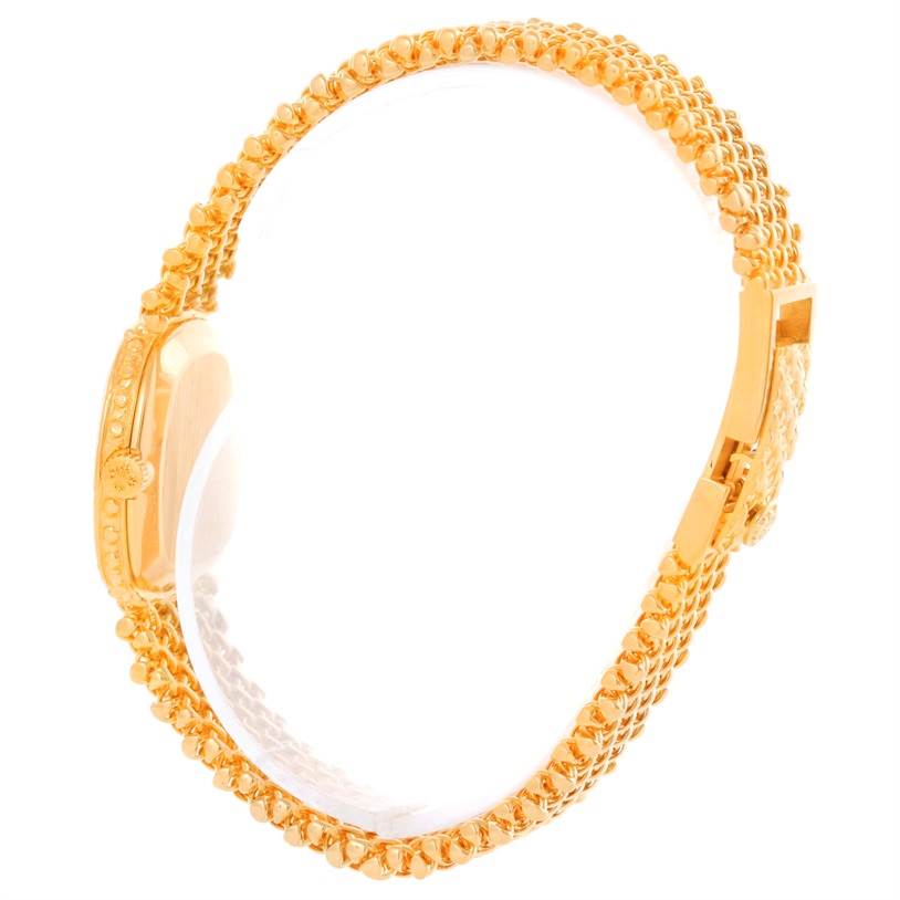 The image shows a side view of a vintage Patek Philippe watch, highlighting its detailed gold bracelet and case.