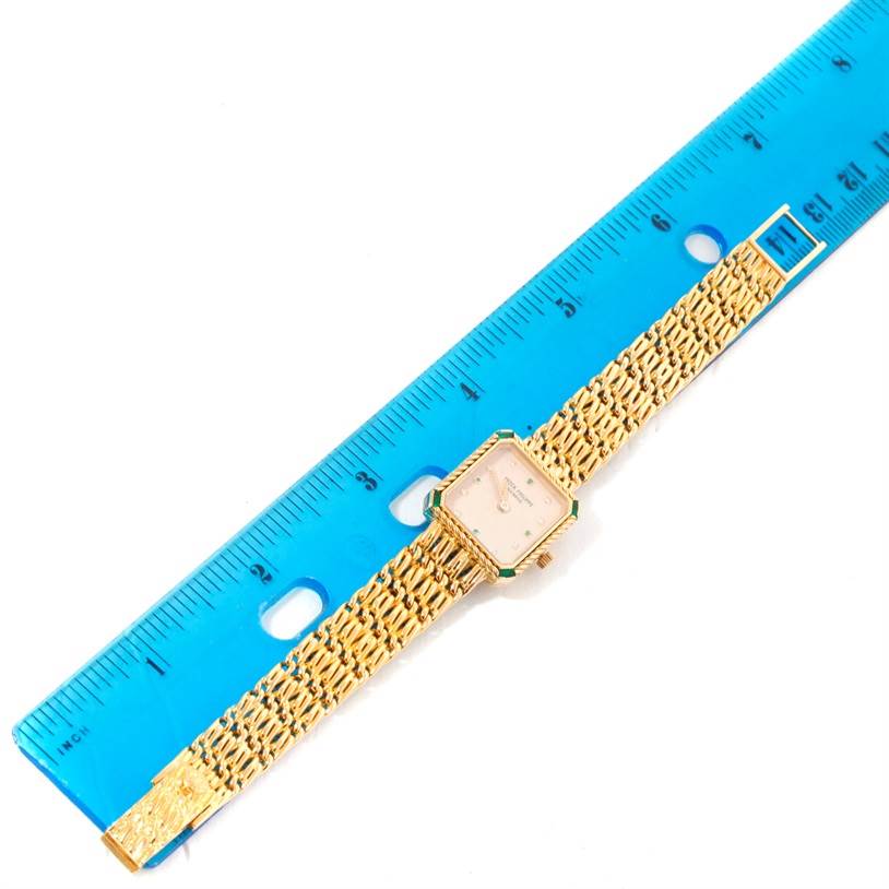 The image shows the Patek Philippe 4667 Women's Yellow Gold Beige Dial 4667 Women's Yellow Gold Beige Dial 18k Yellow Gold Diamond Emerald Ladies Watch 4667 model placed next to a blue ruler.