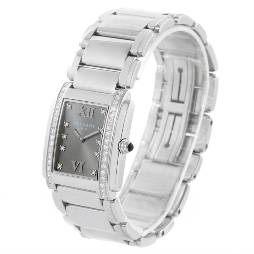 The image shows a Patek Philippe Twenty-4 4910/10A-010 Women's Stainless Steel Grey Dial 4910/10A-010 Women's Stainless Steel Grey Dial watch from a three-quarter angle, highlighting its bracelet and diamond-accented case.