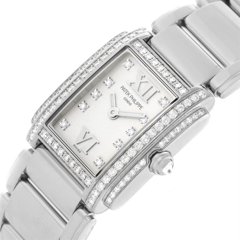 The Patek Philippe Twenty-4 4908/200G-011 Women's White Gold Silver Dial 4908/200G-011 Women's White Gold Silver Dial watch is shown at an angle highlighting the diamond-encrusted bezel, bracelet, and crown.
