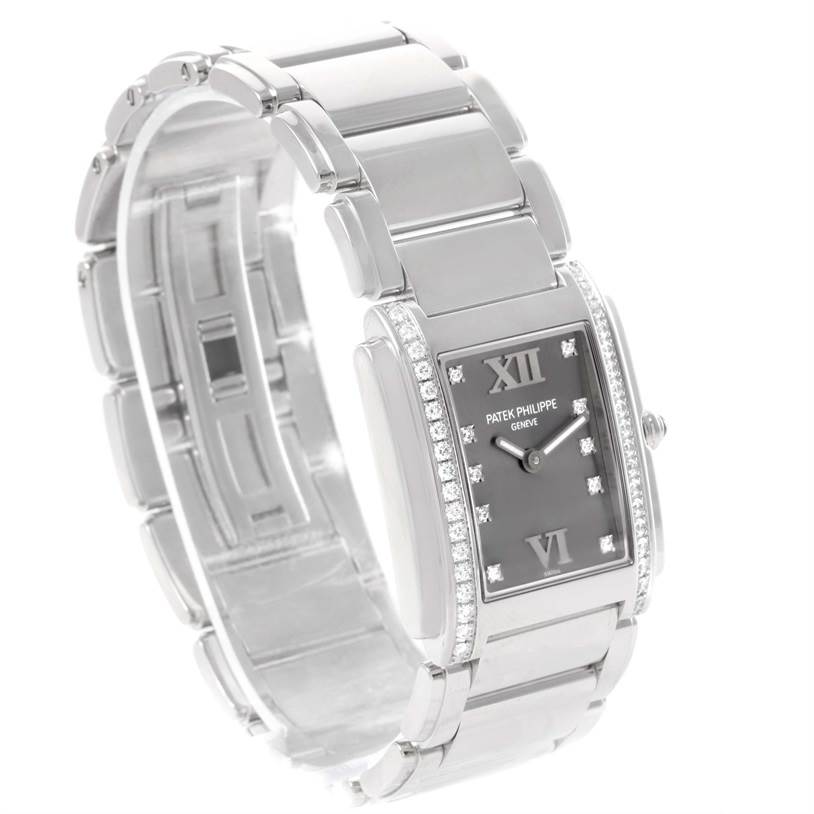 The Patek Philippe Twenty-4 4910/10A-010 Women's Stainless Steel Grey Dial 4910/10A-010 Women's Stainless Steel Grey Dial model watch is shown at an angled side view emphasizing its rectangular case and metal bracelet.