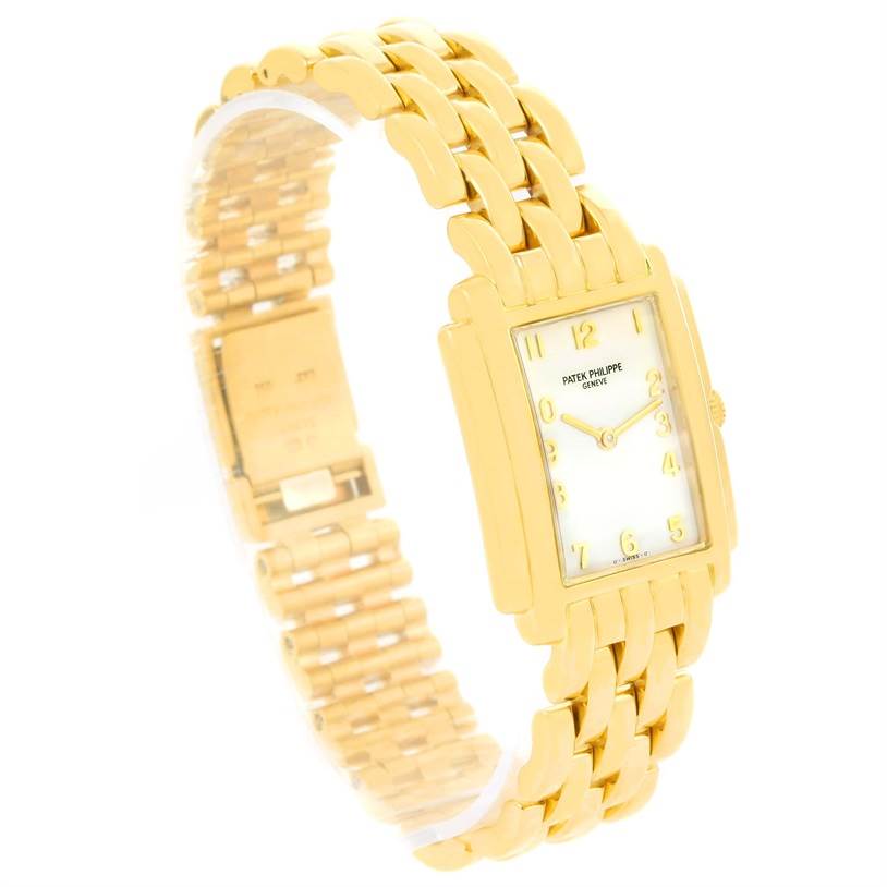 The Patek Philippe Gondolo 4824 Women's Yellow Gold White Dial 4824 Women's Yellow Gold White Dial watch is shown at an oblique angle, highlighting the rectangular face, gold case, and bracelet.
