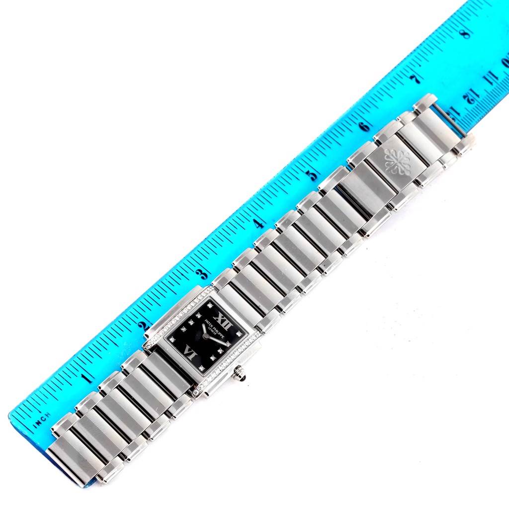 The Patek Philippe Twenty-4 4910/10A-001 Women's Stainless Steel Black Dial 4910/10A-001 Women's Stainless Steel Black Dial watch is shown from a top-down angle, displaying the face, bracelet, and part of the ruler.