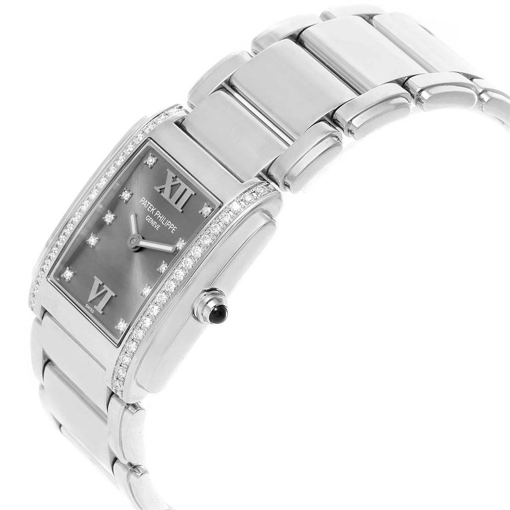 The image shows a side view of the Patek Philippe Twenty-4 4910/10A-010 Women's Stainless Steel Grey Dial 4910/10A-010 Women's Stainless Steel Grey Dial watch, highlighting its rectangular diamond-encrusted case and metallic bracelet.