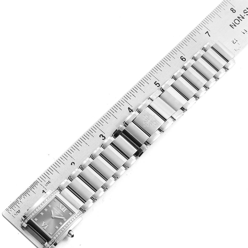 The image shows a top view of the Patek Philippe Twenty-4 4910/10A-010 Women's Stainless Steel Grey Dial 4910/10A-010 Women's Stainless Steel Grey Dial watch with a ruler beside it.