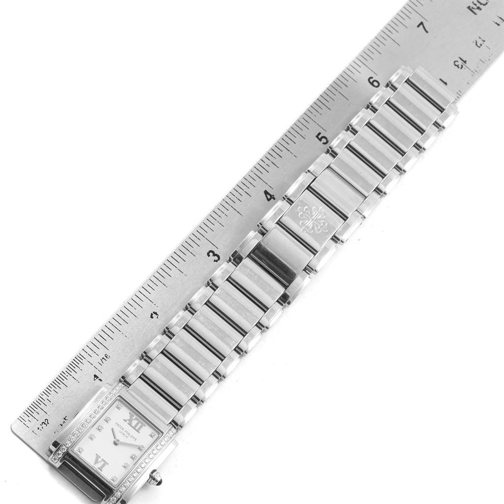 The image shows a top-down view of a Patek Philippe Twenty-4 4910 Women's Stainless Steel Silver Dial 4910 Women's Stainless Steel Silver Dial model watch, displaying its bracelet and part of the dial next to a ruler.